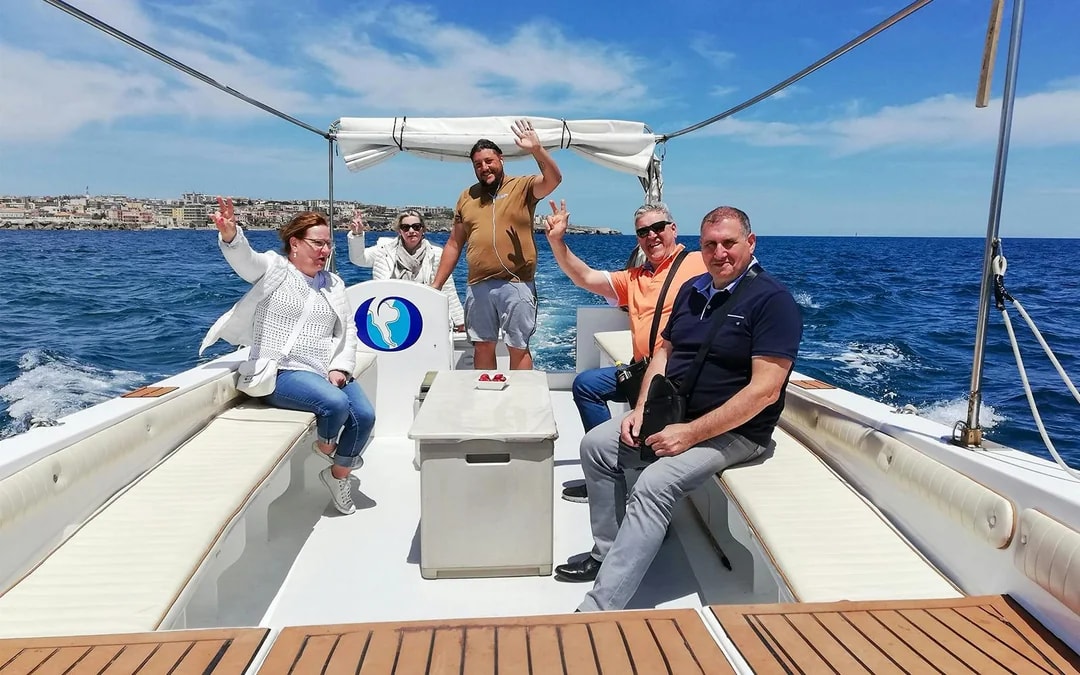 Group enjoying a boat tour to Ortigia Island and sea caves.