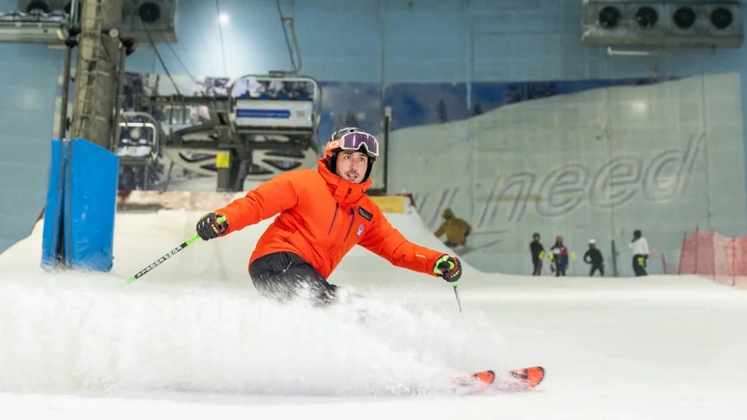 Skier in orange jacket on indoor slope at Ski Dubai.