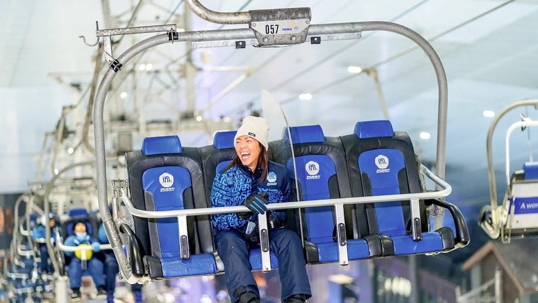 Chairlift ride at Ski Dubai Snow Park with people enjoying the view.
