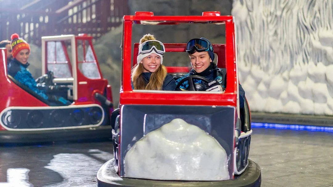 Visitors enjoying bumper cars at Ski Dubai indoor snow park, Dubai, UAE.