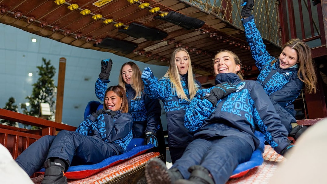 Bobsled ride with people enjoying at Ski Dubai Snow Park.