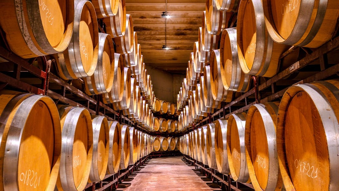 Barrels aging whiskey in a distillery cellar.