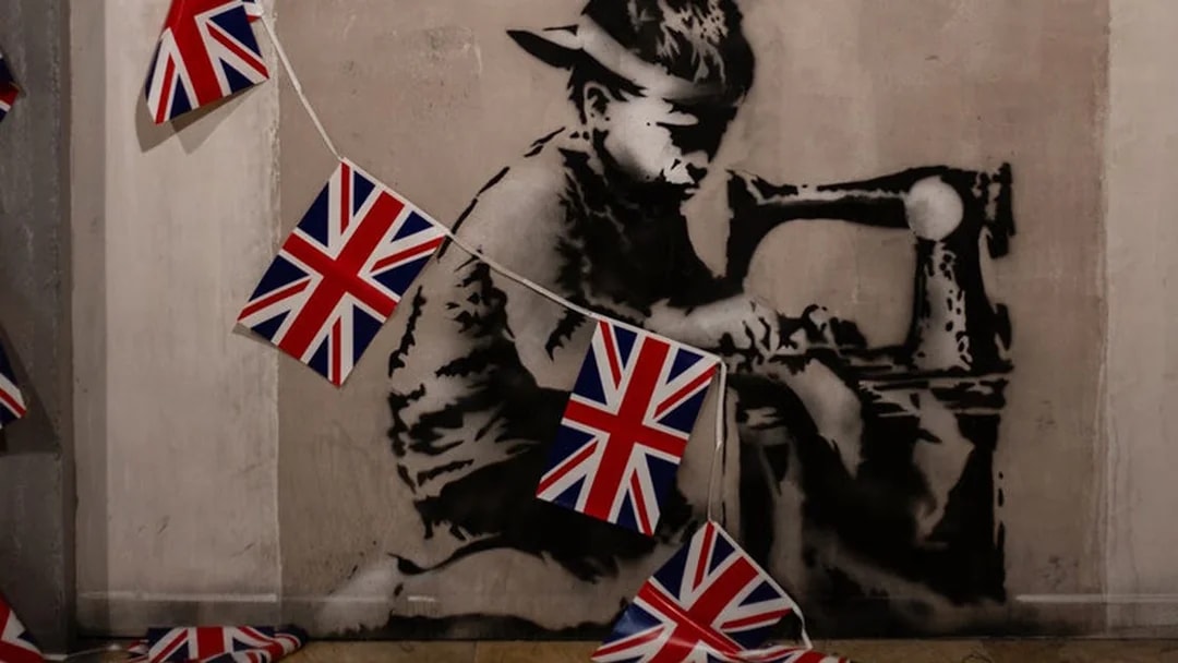 Banksy artwork of a child sewing Union Jack flags, Banksy Museum Barcelona.