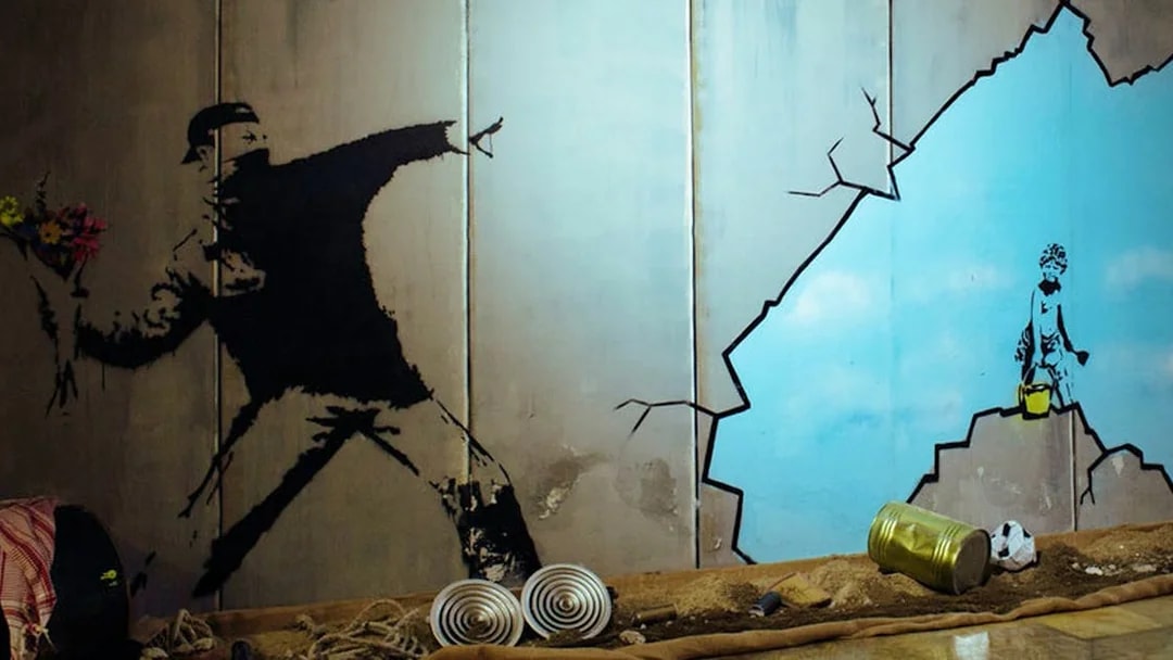 Street art mural at Banksy Museum Barcelona showing a figure throwing flowers.