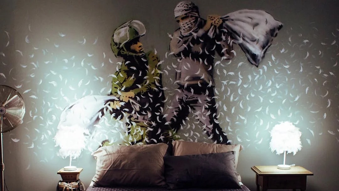 Street art mural of a pillow fight by Banksy at Moco Museum, Amsterdam.