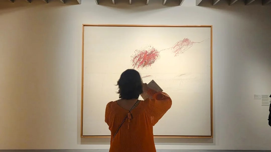 Visitor viewing abstract art at Centre Pompidou Malaga exhibition interior.