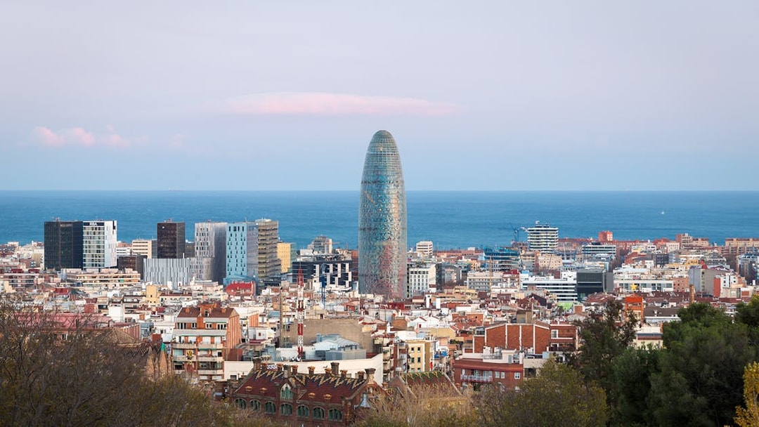Torre Glòries in Barcelona skyline with Mediterranean Sea in the background.