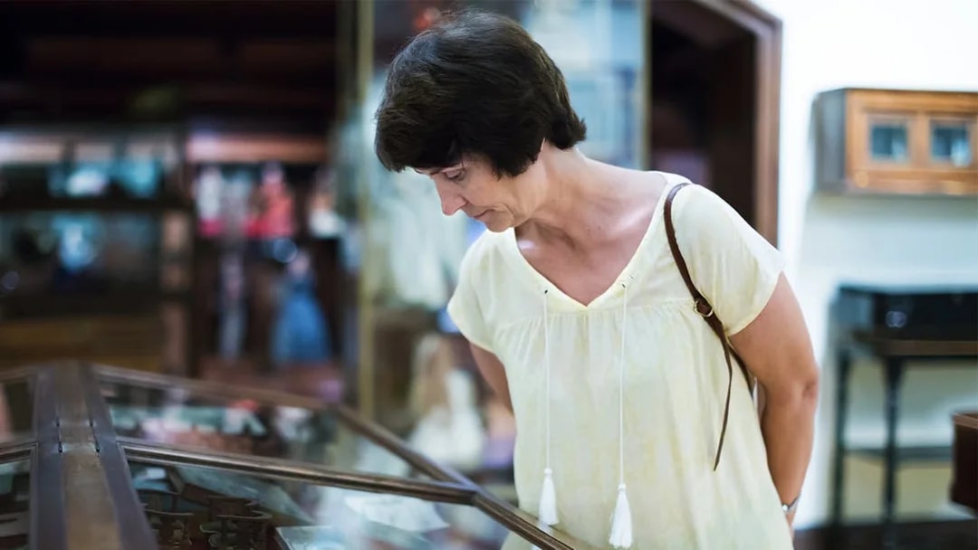 Visitor examining display case at the National Prague Museum.