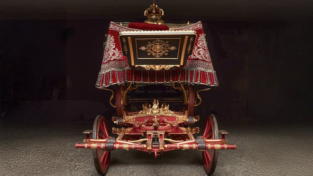 Ornate royal carriage on display at the Royal Collections Gallery.
