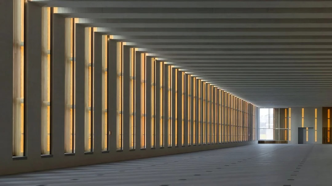 Interior of Royal Collections Gallery with illuminated vertical windows.