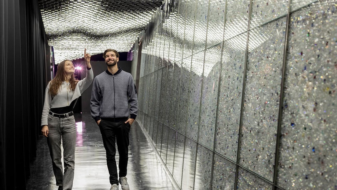 Visitors exploring a sparkling corridor at Swarovski Crystal Worlds.