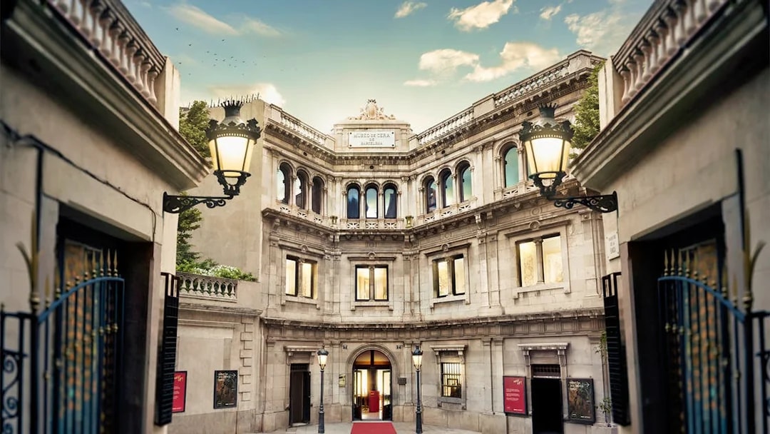 Entrance of Wax Museum in Barcelona with ornate facade and red carpet.