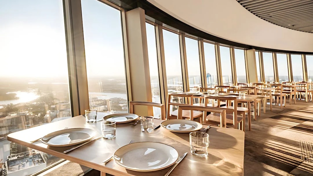 Dining tables set at SkyFeast, Sydney Tower, with panoramic city views.
