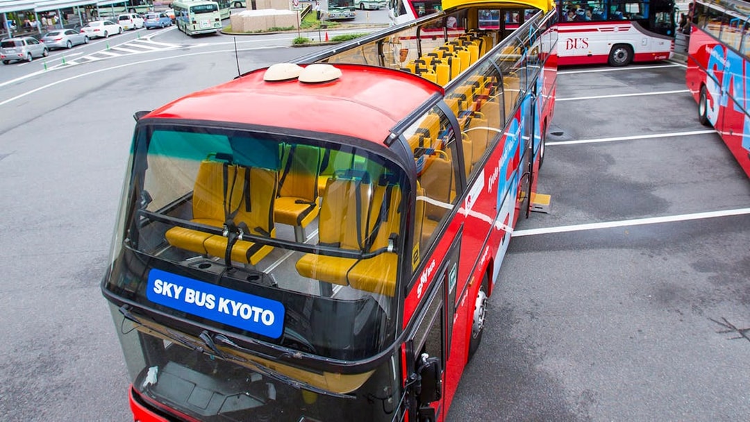 Kyoto sightseeing hop-on hop-off bus parked at a station with open-top seating.