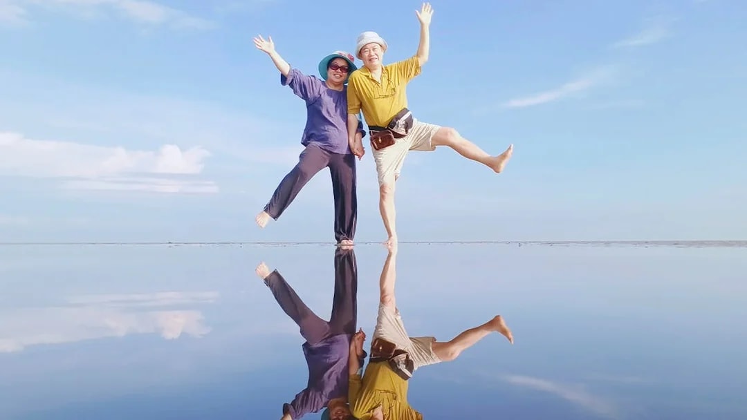 Couple enjoying Sky Mirror Experience in Kuala Selangor with clear reflections.