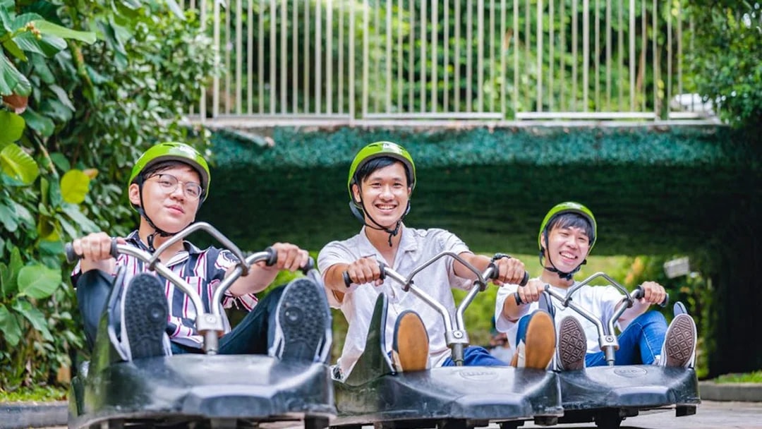 Three people enjoying the Skyline Luge ride in Singapore.