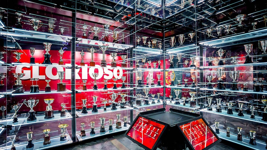 Benfica Stadium museum trophy display with numerous awards on shelves.