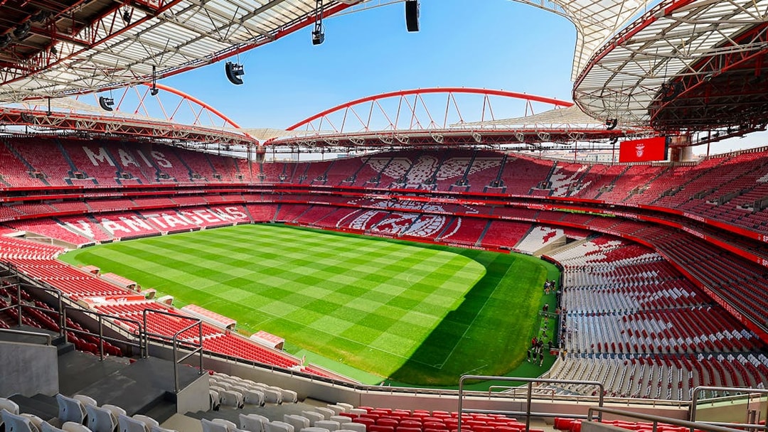 Benfica Stadium view from spectator stand showing green field and red seating.