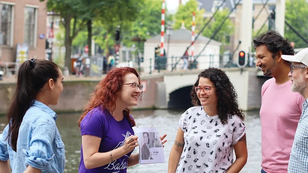 Tour guide with a group by a canal in Amsterdam on a SmallGroup Hidden Gems Tour.