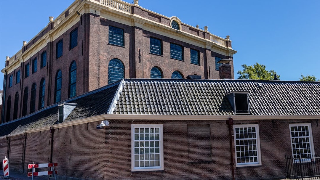 Portuguese Synagogue's exterior with brick facade and arched windows in Amsterdam.