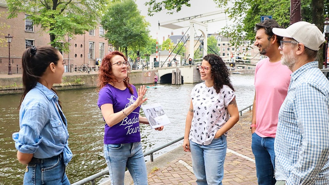 Tour guide with a group by a canal in Amsterdam on a Jewish history tour.