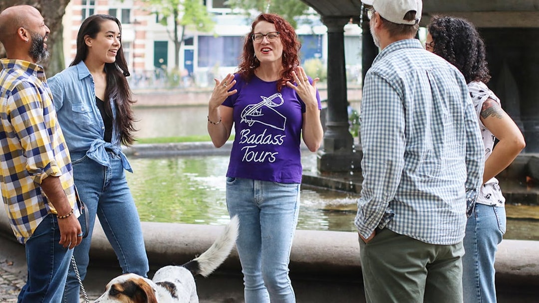 Tour guide leading a small group on a Jewish history tour by a canal.
