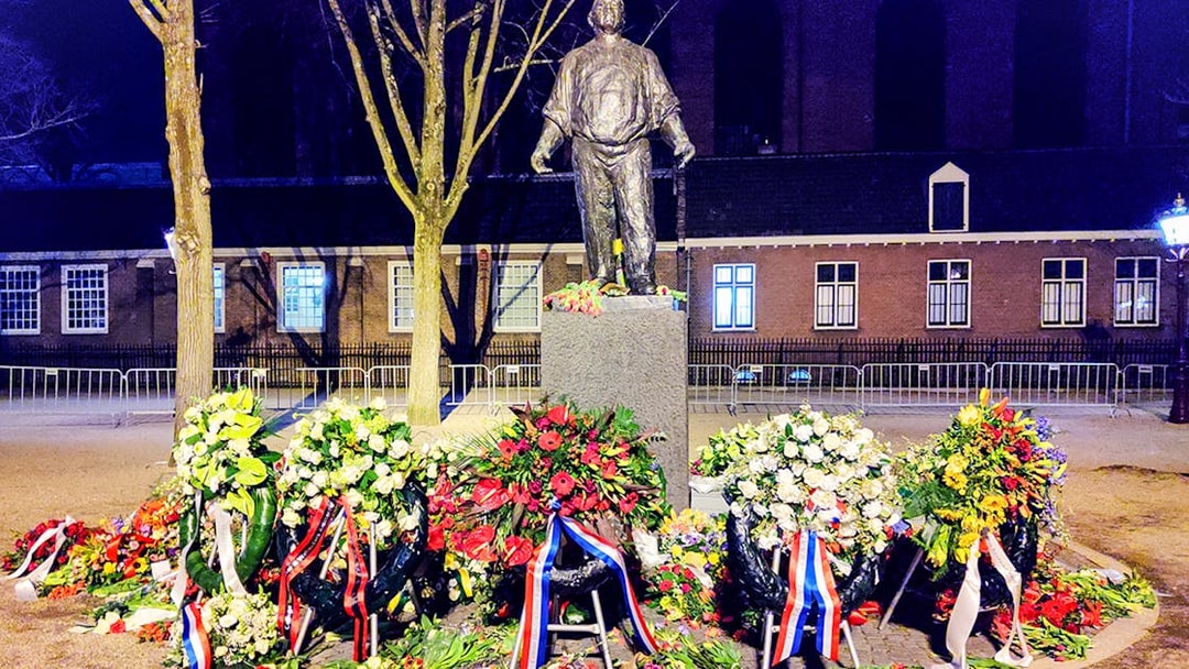 Statue with floral wreaths at Jewish history site in Amsterdam.
