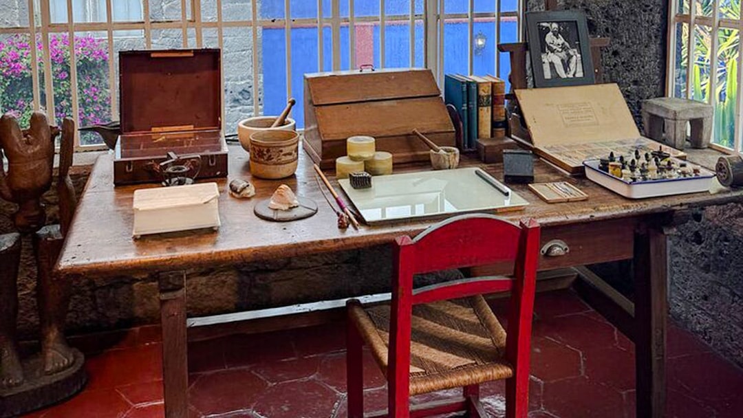 Frida Kahlo Museum desk with art supplies and books in Mexico City.