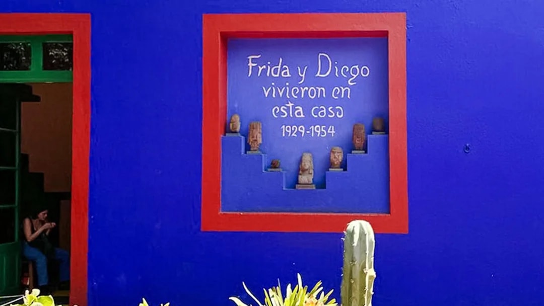 Frida Kahlo Museum blue wall with red-framed niche and sculptures, Coyoacán, Mexico City.