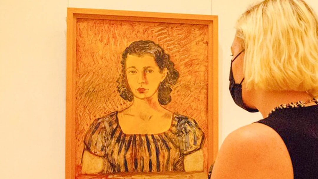 Visitor viewing a portrait at the Frida Kahlo Museum in Mexico City.
