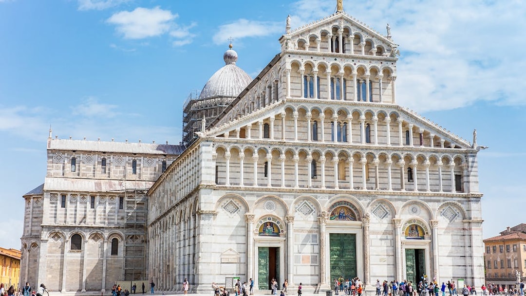 Pisa Cathedral in the Square of Miracles, Pisa, with visitors exploring the site.