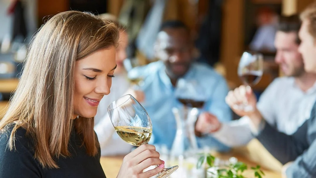 Young woman tasting white wine during Pisa tour.