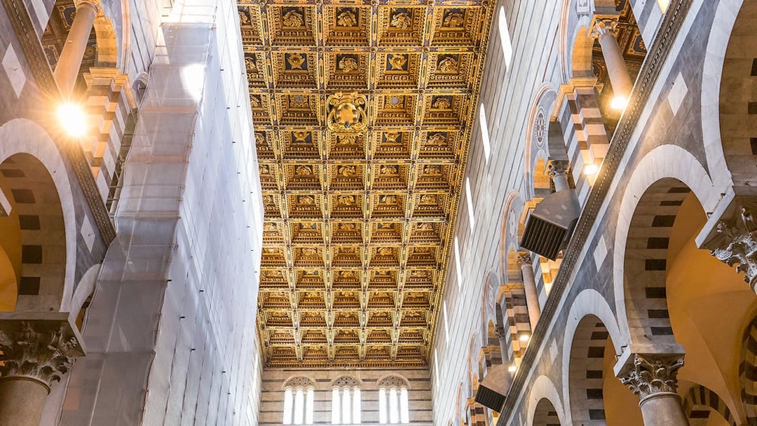 Pisa Cathedral interior with detailed gold roof murals and arches.