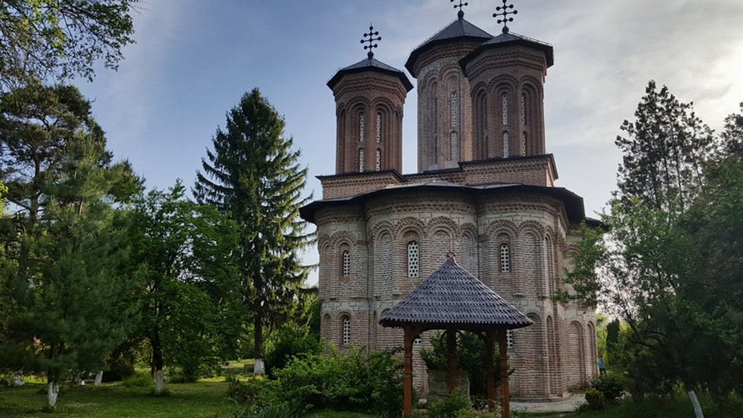 Snagov Monastery with brick architecture surrounded by lush greenery, Romania.