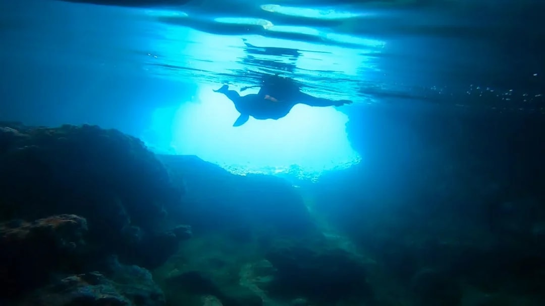 Snorkeler exploring underwater cave in Nea Makri, Athens.