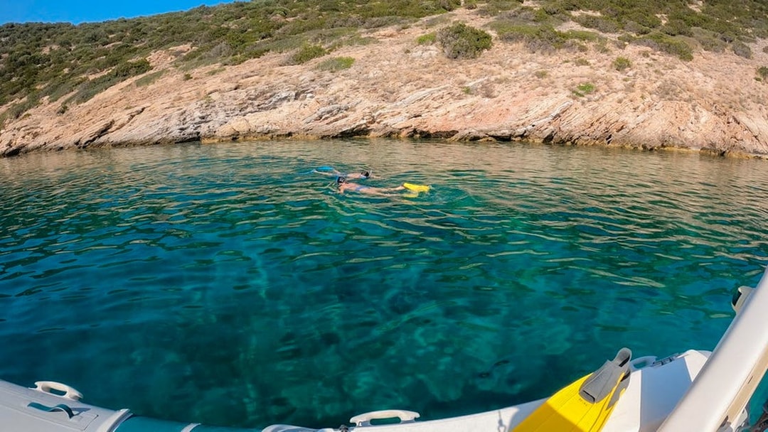 Snorkeler near rocky coast in Nea Makri, Athens, viewed from a boat.