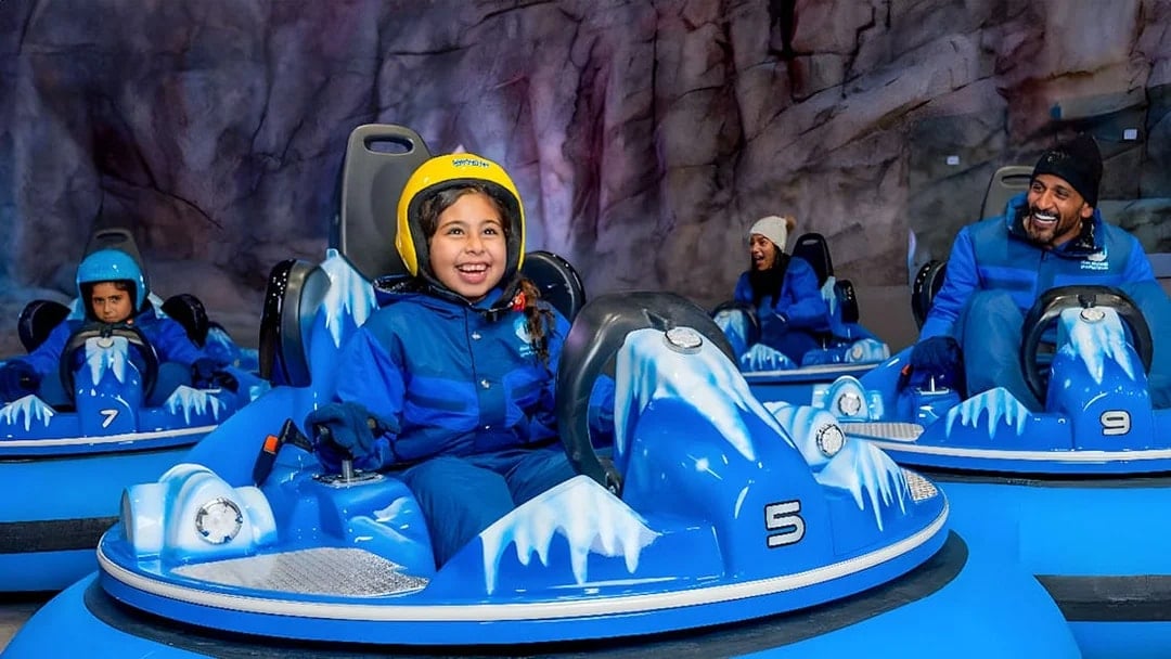 Children and adults enjoying bumper cars at Snow Abu Dhabi's Snow Park.