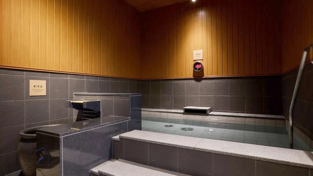 Indoor hot spring bath at Solaniwa Onsen, Japan, with wooden and stone decor.