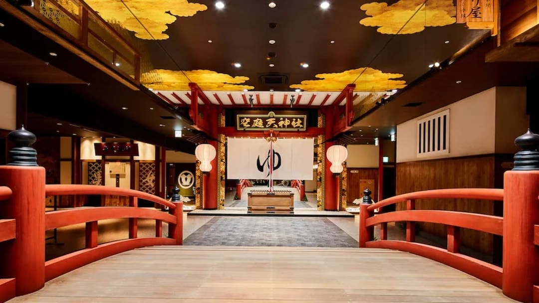 Solaniwa Onsen entrance with red bridge and traditional Japanese decor.