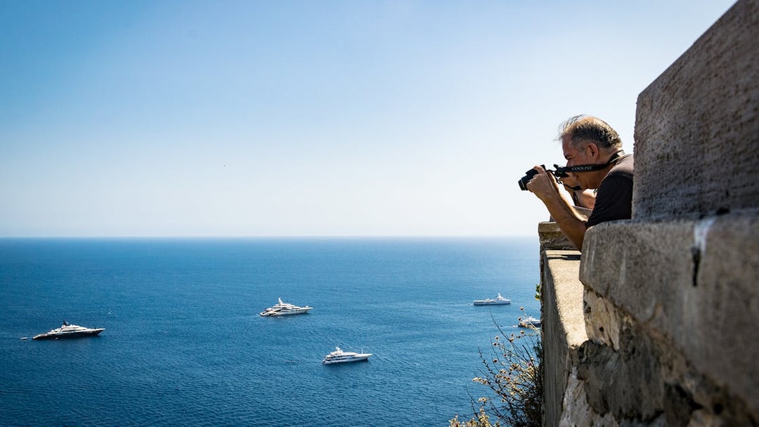 Photographer capturing yachts on the sea near Capri and Anacapri, Italy.