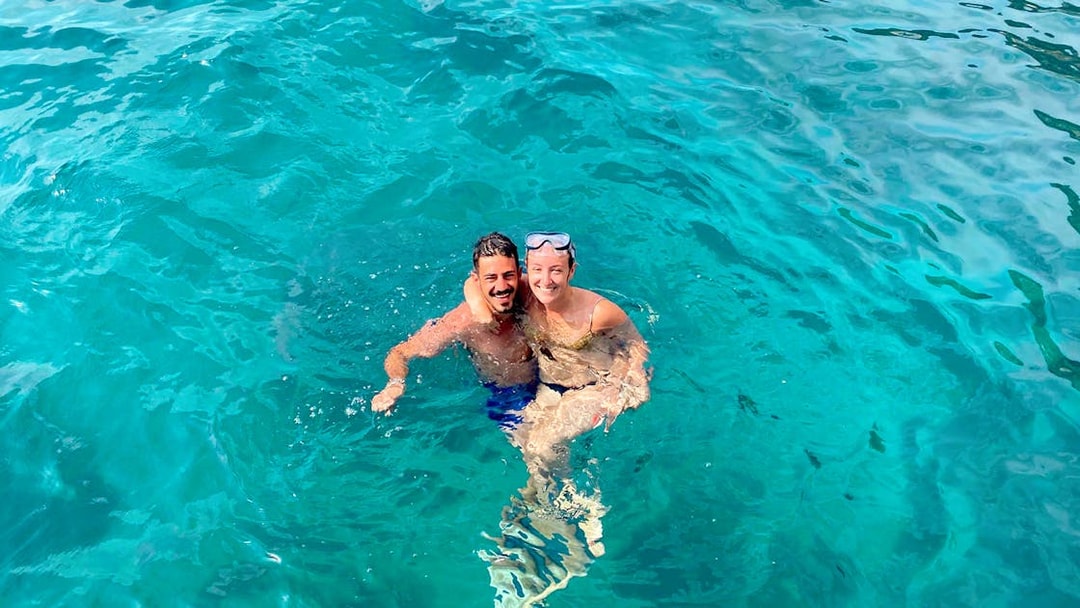 Couple swimming in clear blue waters near Capri on a tour from Sorrento.
