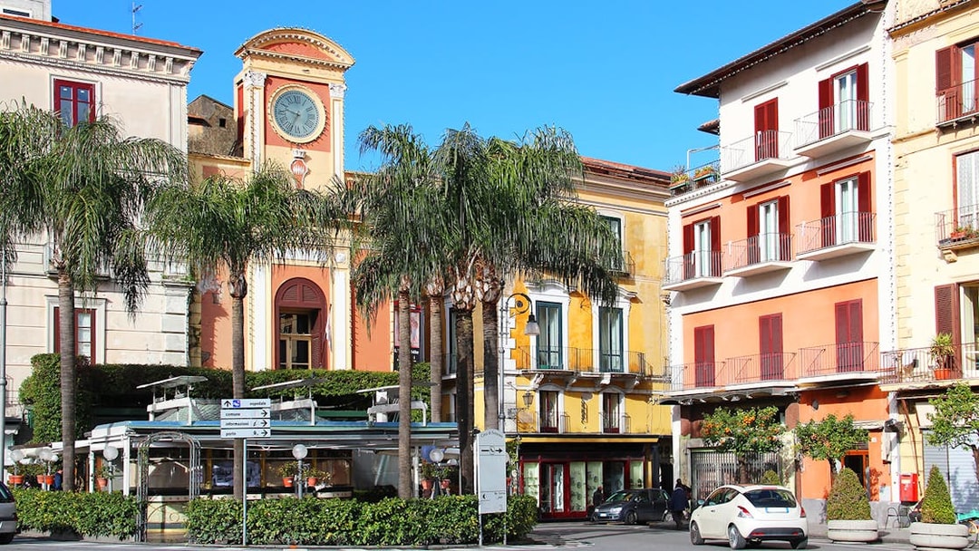 Tasso Square in Sorrento with clock tower and colorful buildings.
