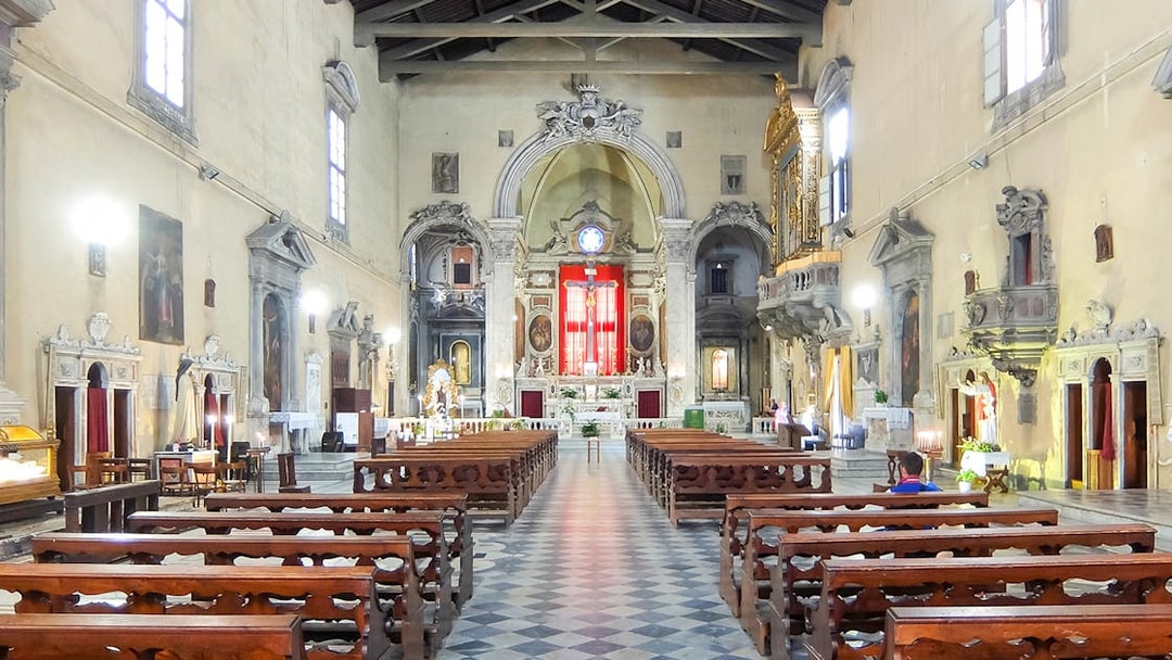 Brancacci Chapel interior with ornate altar and wooden pews, Florence, Italy.