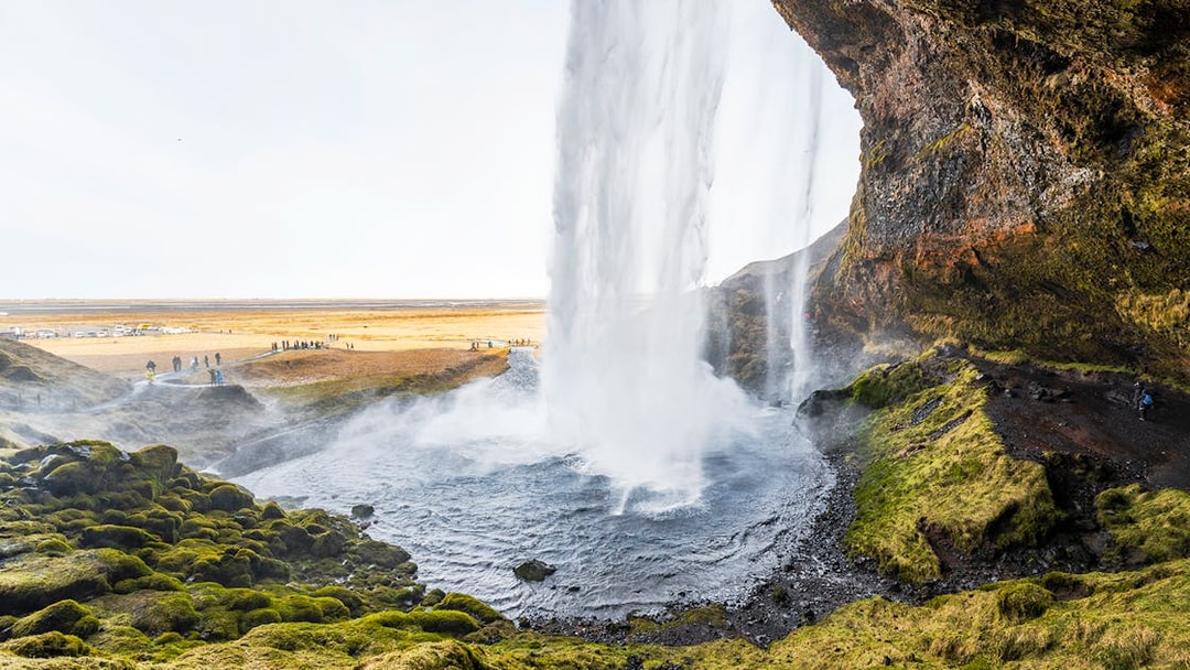 Seljalandsfoss waterfall cascading over mossy cliffs in Southern Iceland.