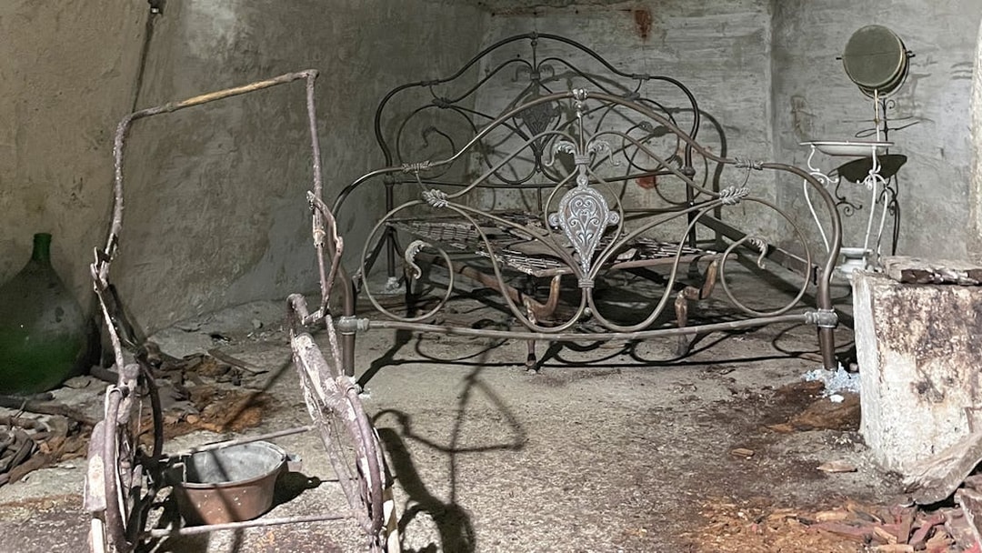 Antique metal bed frame in Naples Underground cave setting.