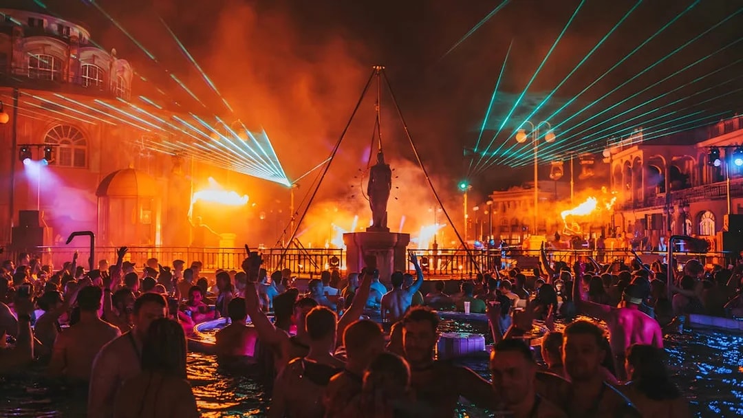 Crowd enjoying Sparty bath party with lights and music at Széchenyi Thermal Bath, Budapest.