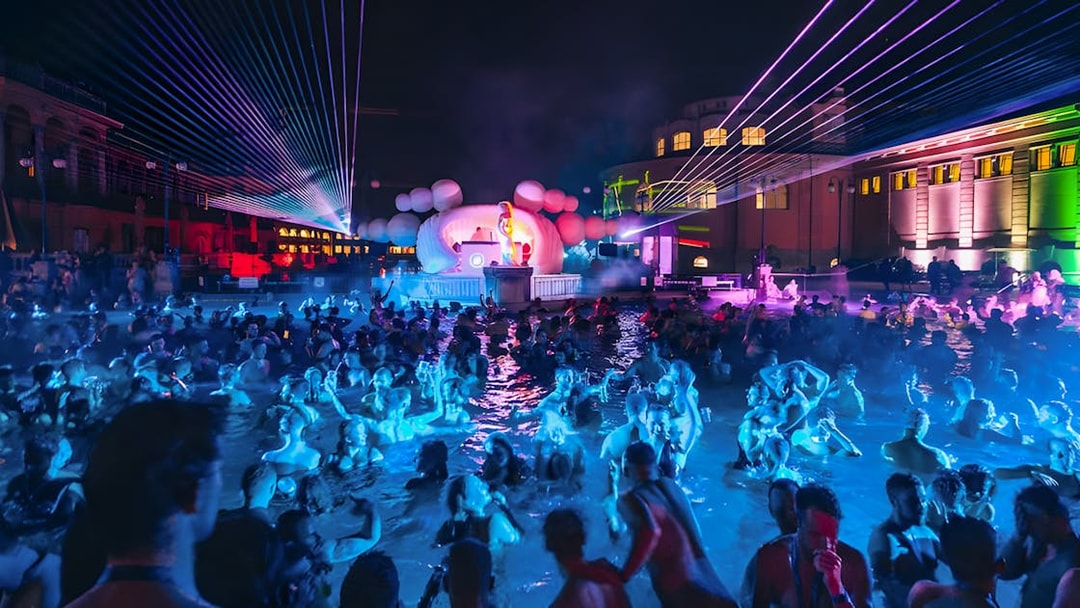 Crowd enjoying Sparty event with DJ and lights at Széchenyi Thermal Bath, Budapest.