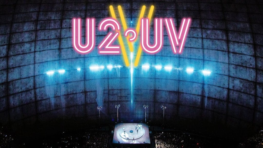 U2 concert at Sphere Las Vegas with neon lights and large audience.