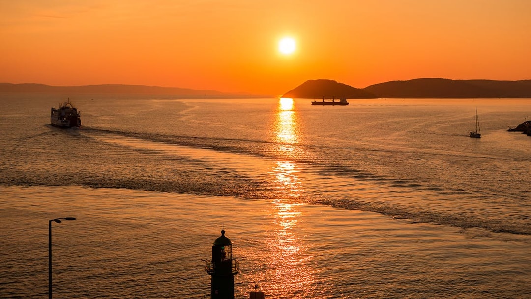 Sunset view of Split Riviera with boats and lighthouse during a panoramic cruise.
