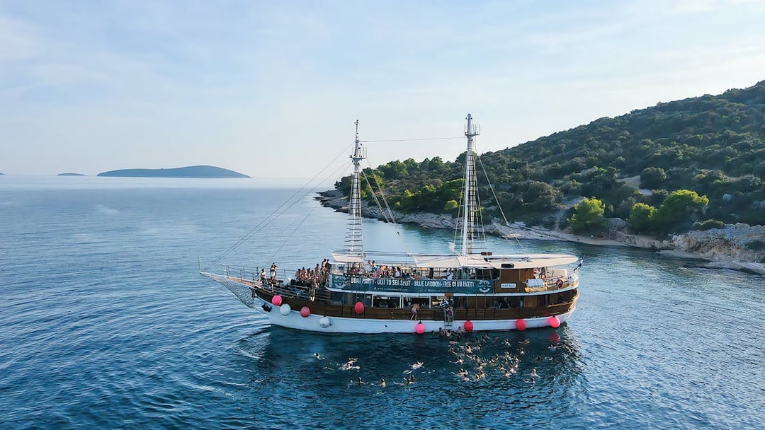 Boat party at Blue Lagoon near Split, Croatia with people swimming and enjoying the sea.